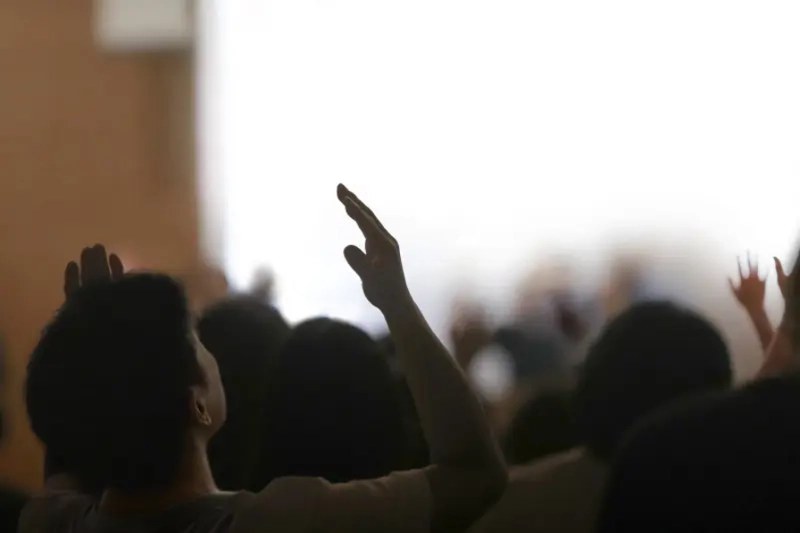 People worshipping with hands raised